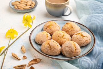 Almond cookies and a cup of coffee on a white concrete background Side view.