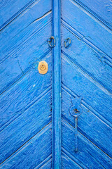 Closed old blue wooden door, clearly aged and time washed.