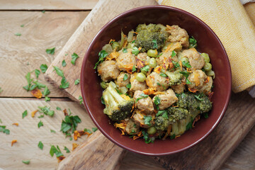 Soy goulash, protein food with stewed vegetables: pea, broccoli, carrot and spices, healthy vegan meal - a source of proteins, closeup, copy space