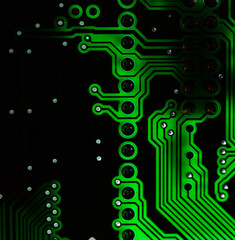 Close-up of a blue printed circuit board (PCB) with stripes of conductors between a transistor and...