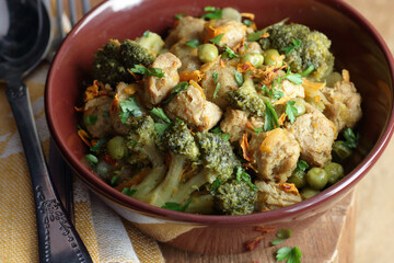 Soy goulash, protein food with stewed vegetables: pea, broccoli, carrot and spices, healthy vegan meal - a source of proteins, closeup, copy space