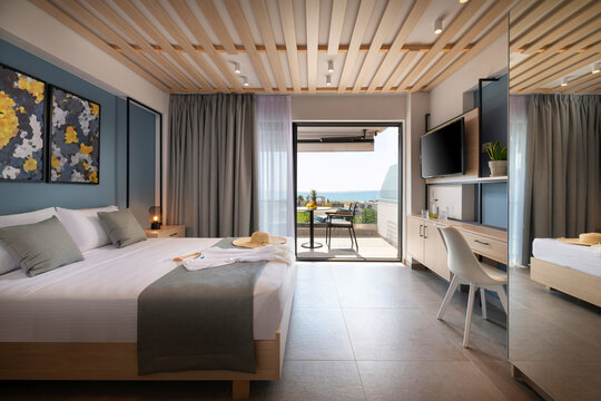 Side view of modern loft style bedroom with metal details, wooden furniture, abstract decor. Hotel apartment with sea view balcony, open air French window terrace