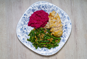 Chicken breast with beetroot sauce garnished with green beans and walnuts