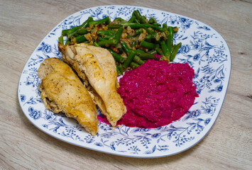 Chicken breast with beetroot sauce garnished with green beans and walnuts