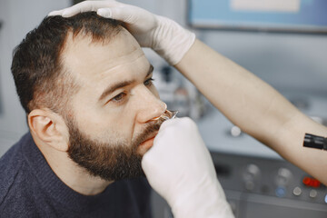 Man patient in the medical office. Doctor in medical mask.