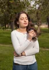 Girl in the park with a cup of coffee