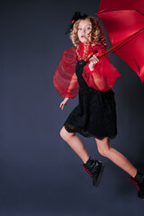child girl jumping up with red umbrella