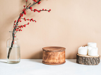 Winter home decoration with candles, branch with red berries and wood round box
