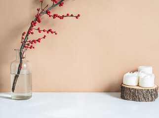 Winter home decoration with candles and branch with red berries in glass vase