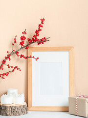 Ilex branches in bottle, candles and wood blank frame mock up