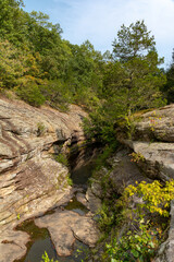 Barren rock formations and small creek run between the trees in the Bell Smith Springs area of the Shawnee National Forest.