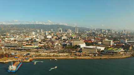 Naklejka premium Aerial view of panorama of Cebu city with skyscraper, buildings and seaport with ships and ferries in the early morning. Philippines.