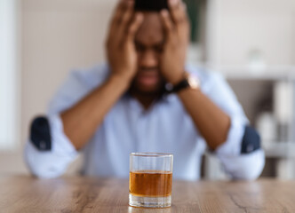 Glass of whiskey over drunk office manager