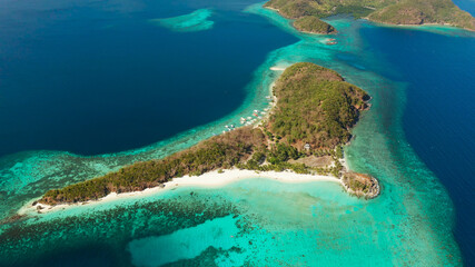 aerial view tropical island with sand white beach, palm trees. Malcapuya, Philippines, Palawan. Tropical landscape with blue lagoon, coral reef
