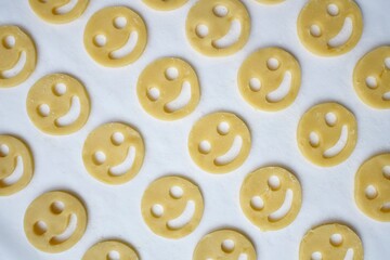 unbaked cookies in the shape of a smiley as a background