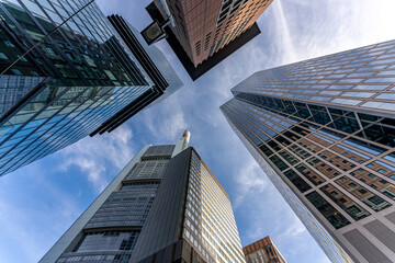 Fototapeta na wymiar low angle view of four skyscrapers with different facade designs under the blue sky
