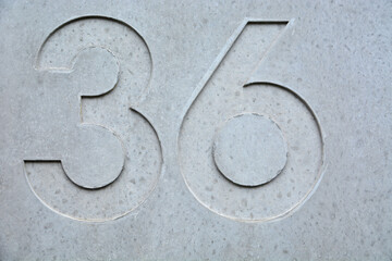 A blue house number plaque, showing the number thirty six (36)
