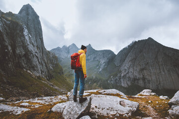 Man with backpack hiking solo in Norway mountains travel vacations outdoor adventure trekking active healthy lifestyle weekend getaway - obrazy, fototapety, plakaty
