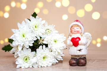 Angel girl with heart in hands and white flowers