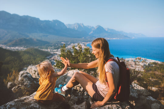 Family mother with daughter traveling in Turkey active vacation mom and child hiking together high five hands fun on mountain summit healthy lifestyle outdoor happiness emotions