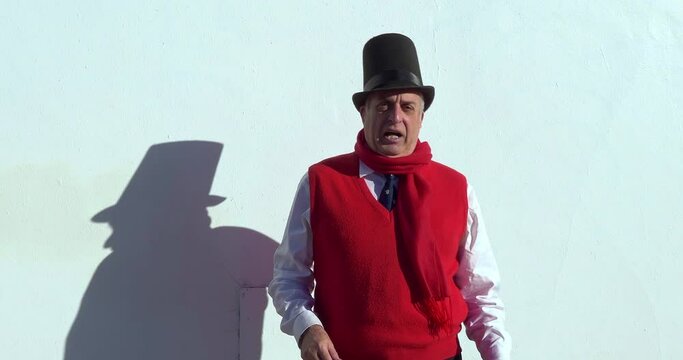 Actor in cylinder hat and sunglasses entertains people by playing soprano recorder at Christmas in Los Angeles, California, 4K