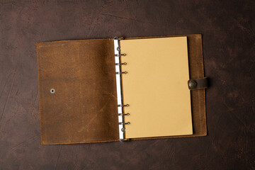 brown leather diary and pen on brown background or table