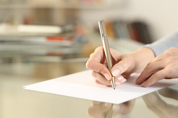 Woman hands writing letter on paper sheet on table