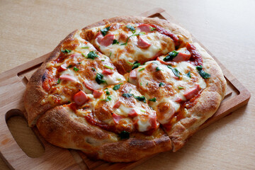 pizza with salami and cheese on a wooden board