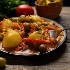 Mexican style cod called a la vizcaina on wooden background