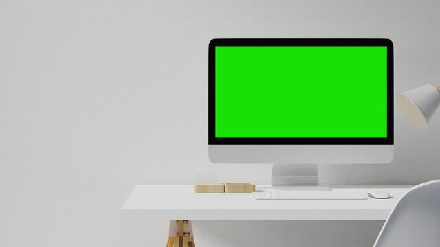 Computer with green screen on working table.