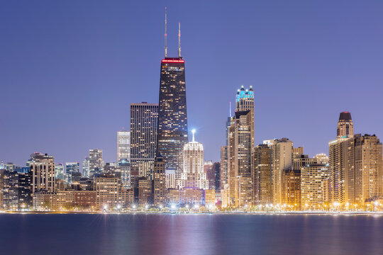 Illuminated view of 875 North Michigan Avenue (John Hancock Center) surrounded by skyscrapers at dusk, Chicago, USA