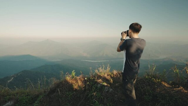 Photographer photographing mountain view at Doi Pha Tang viewpoint the famous tourist attraction in Chiang Rai province, Thailand