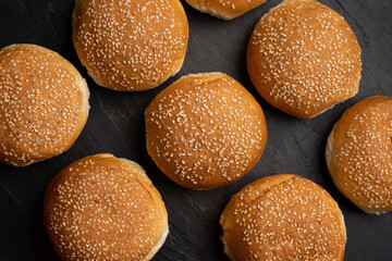 Burger bun bread with sesame seeds on dark background