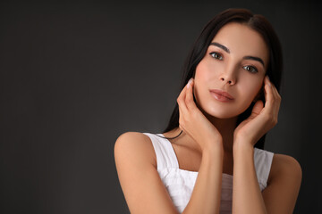 Portrait of beautiful young woman on dark grey background