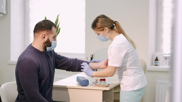 A laboratory worker takes a blood sample for antibodies to the virus. The nurse is preparing to draw blood. The patient donates blood