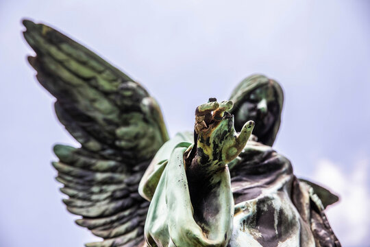 Weathered statue of angel reaching toward camera