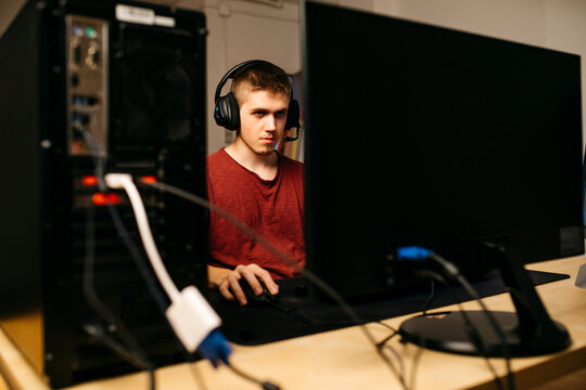 Young man playing video games with computer at desk