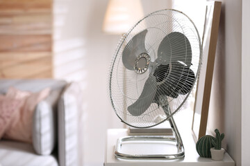 Modern electric fan on white table indoors. Space for text