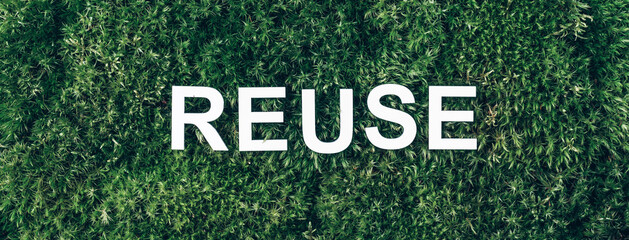 Word Reuse on moss, green grass background. Top view. Copy space. Banner. Biophilia concept. Nature backdrop