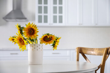 Bouquet of beautiful sunflowers on table in kitchen