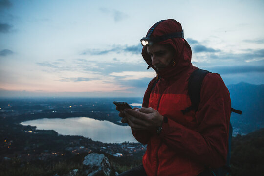 Mature man using mobile phone against sky at twilight