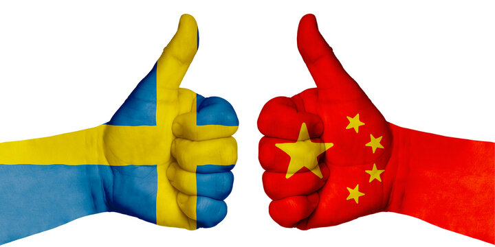 Two hands with a raised finger. They portray the gesture class, managed to negotiate. On the hands of the image of the flags of countries, China and Sweden