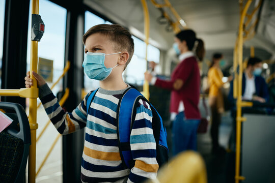 Schoolboy wearing protective face mask while commuting by public bus.