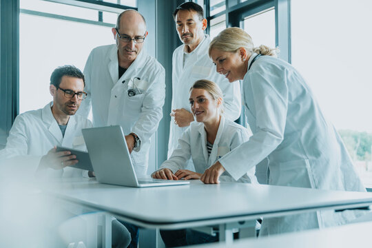 Team of doctors and scientist using laptop while working at office