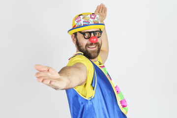 The clown is a man in a bright blue and yellow suit, glasses and a hat, playing emotionally.
