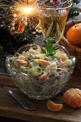 Obraz na płótnie Canvas Traditional Russian Christmas Salad Olivier with champagne and tangerines