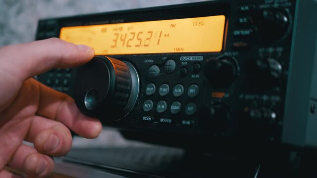 Male Hand Tunes Radio Communication Transceiver at Stationary Radio Station