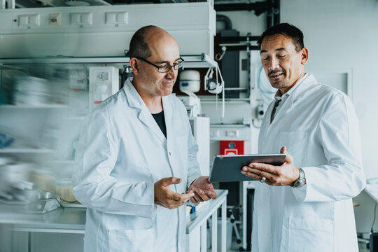 Scientist using digital tablet while standing at laboratory