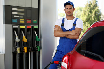 Worker refueling car at modern gas station