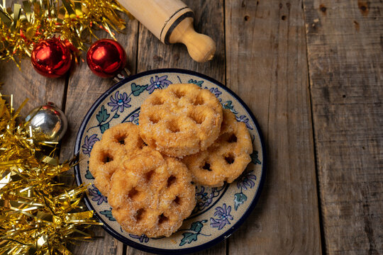 Mexican fritter with sugar and cinnamon called bunuelo on wooden background